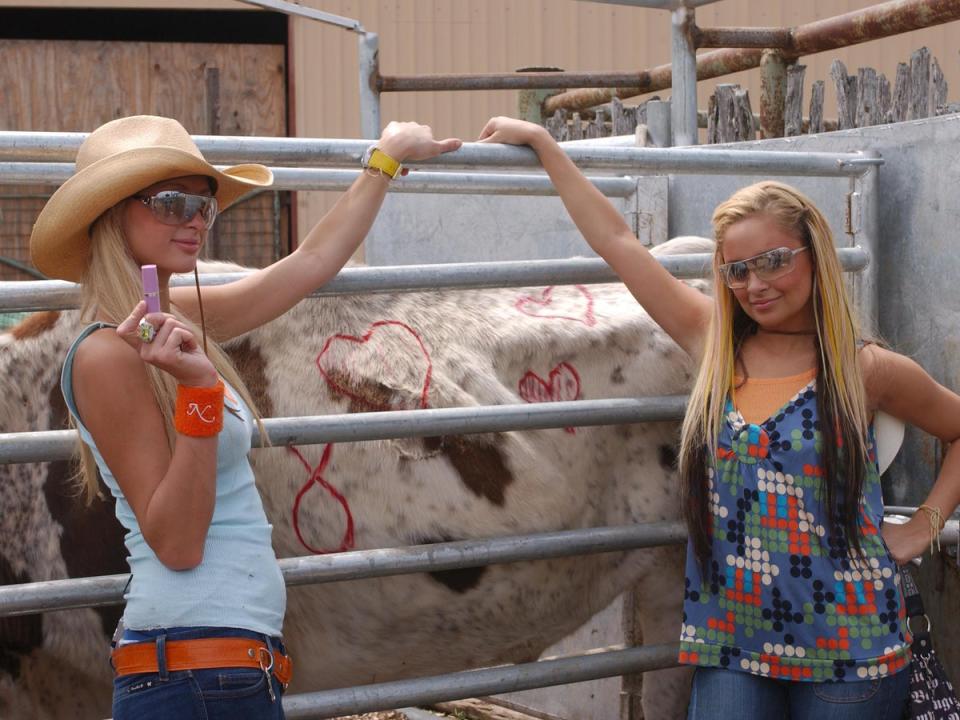 Moo point: Hilton and Nicole Richie pose with a cow during filming of their seminal reality series ‘The Simple Life’ in 2003 (Shutterstock)