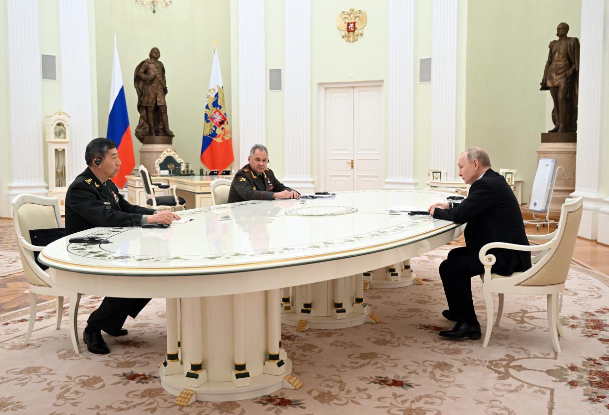 Russian president Vladimir Putin, China’s defence minister Li Shangfu and Russian defence minister Sergei Shoigu attend a meeting in Moscow, Russia, 16 April 2023 (EPA)