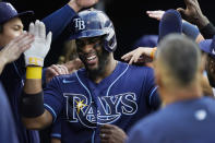 Tampa Bay Rays' Yandy Diaz is greeted in the dugout after scoring on a two-run home run hit by teammate Brandon Lowe during the third inning of a baseball game against the Detroit Tigers, Thursday, Aug. 4, 2022, in Detroit. (AP Photo/Carlos Osorio)