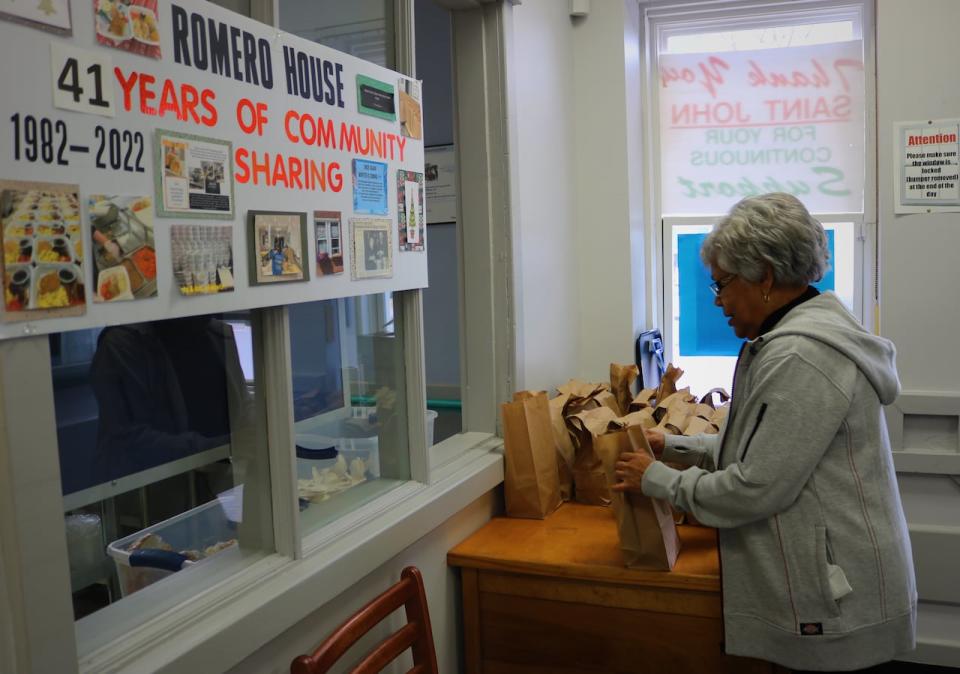 Alfreda Hector, pictured getting ready to hand bagged lunches out the take-out window at Romero House, has been volunteering at the soup kitchen for 17 years.  