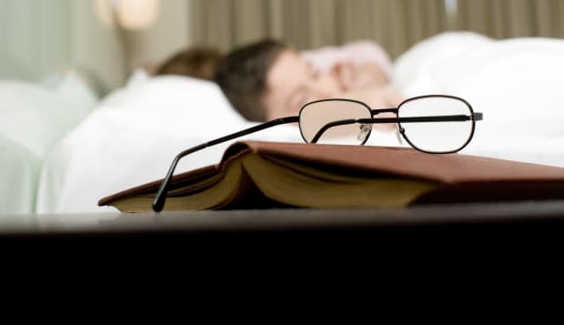 Eyeglasses and book on nightstand