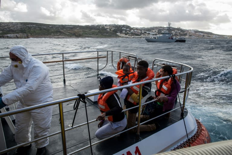 The migrants are transferred from the rescue ships to Maltese coastguard vessels on their way to Malta