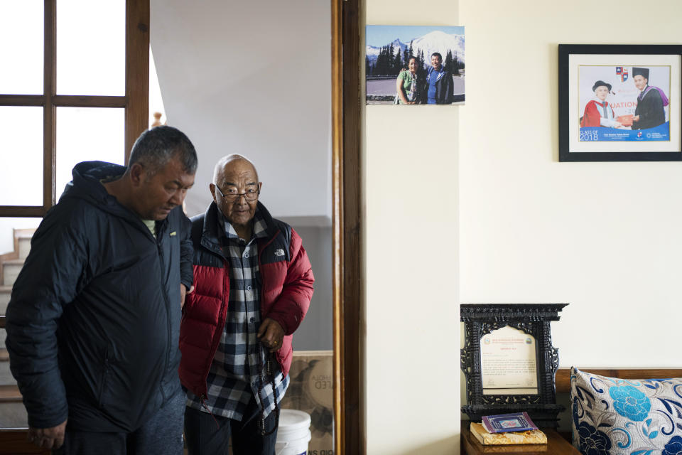 Kanchha Sherpa, right, is helped by his son Tsering Sherpa before an interview with Associated Press at his residence in Kathmandu, Nepal, Saturday, March 2, 2024. Kanchha Sherpa, 91, was among the 35 members in the team that put New Zealander Edmund Hillary and his Sherpa guide Tenzing Norgay atop the 8,849-meter (29,032-foot) peak on May 29, 1953. (AP Photo/Niranjan Shrestha)