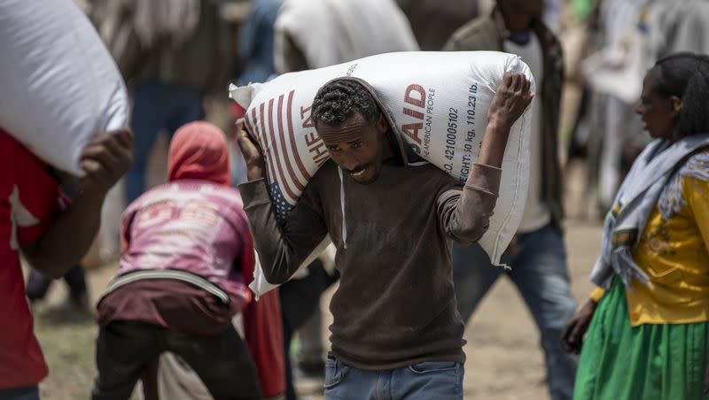 An Ethiopian man carries a sack of wheat on his shoulders to be distributed by the Relief Society of Tigray in the town of Agula, in northern Ethiopia in 2021. Earlier this year, the United States aid agency USAID  suspended all food assistance to the region of Tigray “until further notice” while it investigates the theft of humanitarian supplies.