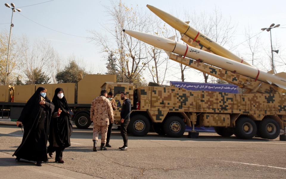 Iranian women walk next to Zolfaghar-Basir and Dezful (R) missiles displayed at Mosallah mosque on the occasion of second anniversary of an Iran missile attack at a US military base in Iraq following the assassination of a former top Iranian commander, in Tehran, on January 7, 2022.