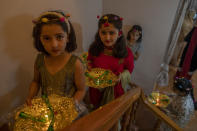 Relatives of Kashmiri bride carry henna and candles inside a decorative basket during henna ceremony of a wedding on the outskirts of Srinagar, Indian controlled Kashmir, Tuesday, Sept. 16, 2020. The coronavirus pandemic has changed the way people celebrate weddings in Kashmir. The traditional week-long feasting , elaborate rituals and huge gatherings have given way to muted ceremonies with a limited number of close relatives attending. With restrictions in place and many weddings cancelled, the traditional wedding chefs have little or no work. The virus has drastically impacted the life and businesses in the region. (AP Photo/ Dar Yasin)