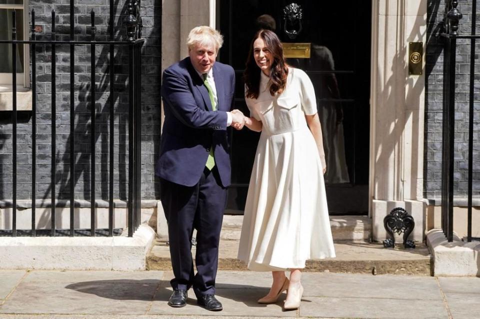 阿德恩（右）與英國首相強生握手，「從頭到腳」拷貝凱特王妃2016年時的造型。（翻攝breitbart.com官網）