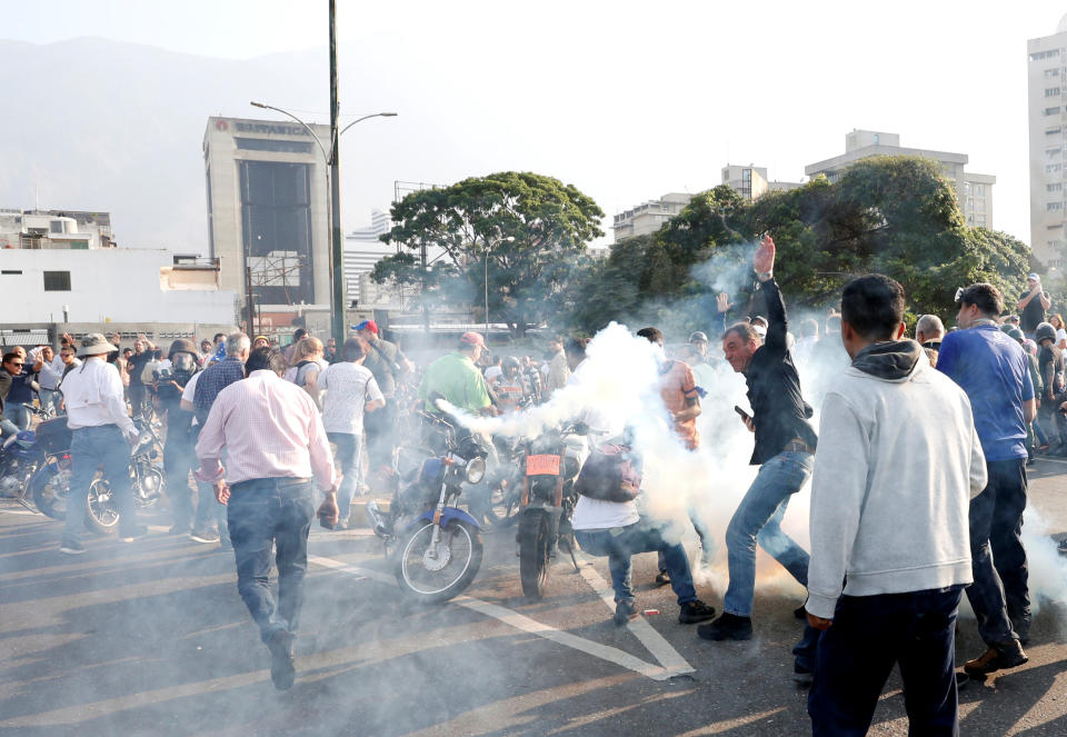 People react to tear gas near the Generalisimo Francisco de Miranda Airbase "La Carlota", in Caracas, Venezuela April 30, 2019. (Photo: Carlos Garcia Rawlins/Reuters)