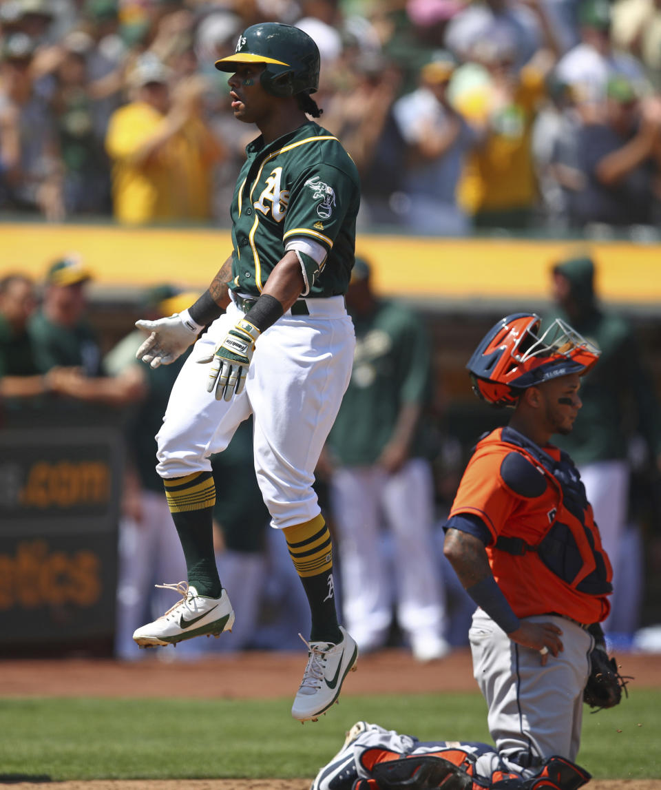 Oakland Athletics' Khris Davis, left, celebrates behind Houston Astros catcher Martin Maldonado after hitting a two-run home run off pitcher Justin Verlander in the third inning of a baseball game Sunday, Aug. 19, 2018, in Oakland, Calif. (AP Photo/Ben Margot)