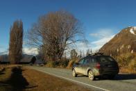 A car drives along Mt Aspiring Road in Wanaka, New Zealand.