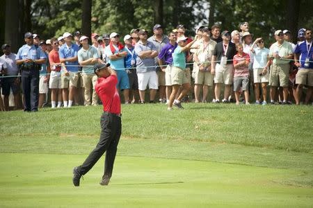 Tiger Woods hits his second shot from the fairway on the 2nd hole in the final round of the Quicken Loans National golf tournament at Robert Trent Jones Golf Club. Mandatory Credit: Rafael Suanes-USA TODAY Sports