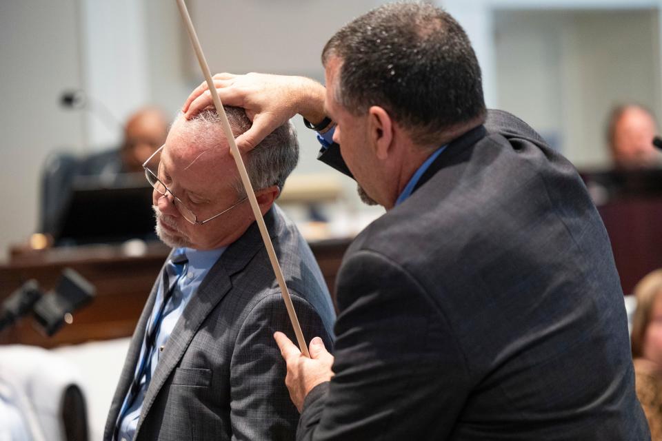 Crime scene specialist Kenneth Kinsey, right, shows where he believes a shotgun round entered Paul Murdaugh during Alex Murdaugh's double murder trial at the Colleton County Courthouse on Thursday, Feb. 16, 2023, in Walterboro, S.C. The 54-year-old attorney is standing trial on two counts of murder in the shootings of his wife and son at their Colleton County home and hunting lodge on June 7, 2021. 
