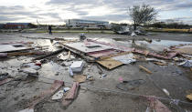 Johnny Graham, back, walks past his storm damaged office Tuesday, Jan. 24, 2023, in Pasadena, Texas. A powerful storm system took aim at Gulf Coast Tuesday, spawning tornados that caused damage east of Houston. (AP Photo/David J. Phillip)