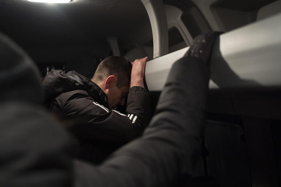 A man leans on an overhead luggage rack in a bus after crossing the border with Russia in Sumy region, Ukraine, Wednesday, Nov. 22, 2023. An average of 80-120 people return daily to Ukraine from territories held by Russia through an unofficial crossing point between the two countries amid a brutal war. Those who opt for this route endure painstaking searches from both sides and trek on foot for more than 2 kilometers through the grey zone. (AP Photo/Hanna Arhirova)