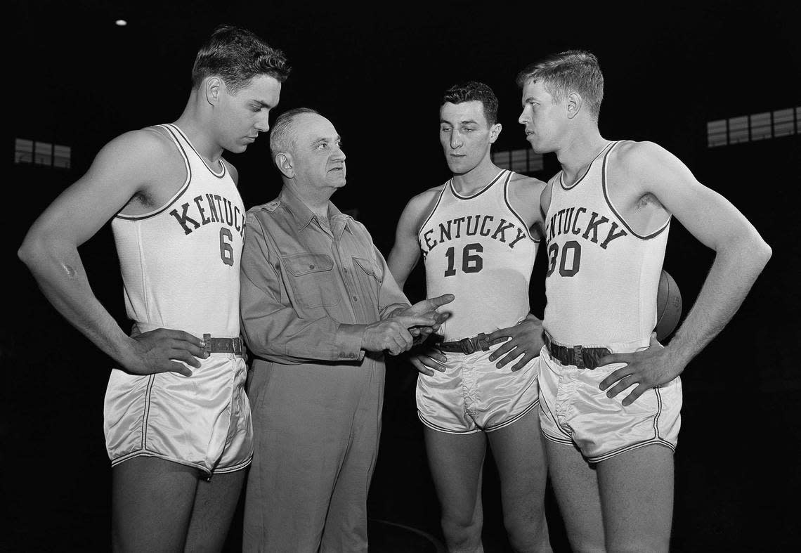 Kentucky head coach Adolph Rupp talked in 1954 with Cliff Hagan (6), Lou Tsioropoulos (16) and Frank Ramsey (30). AP