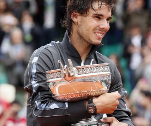 Spain's Rafael Nadal clutches his trophy after winning the French Open in Paris on Monday. Nadal clinched his record seventh French Open title on Monday, defeating world number one Novak Djokovic 6-4, 6-3, 2-6, 7-5 and shattering the Serb's dream of Grand Slam history