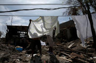 <p>People hang sheets on power lines in front of their destroyed house after Hurricane Matthew hit Jeremie, Haiti, October 10, 2016. (Carlos Garcia Rawlins/Reuters)</p>