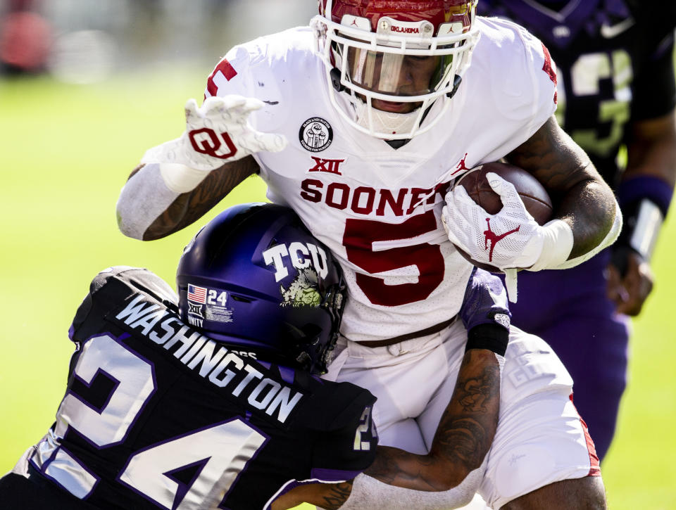 Oklahoma running back T.J. Pledger (5) scores a touchdown as TCU safety Ar'Darius Washington (24) defends during the first half of an NCAA College football game, Saturday, Oct. 24, 2020, in Fort Worth, Texas. (AP Photo/Brandon Wade)