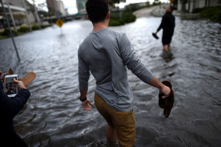 Friends wade through floodwaters after Hurricane Irma in Jacksonville, Florida U.S. September 11, 2017. REUTERS/Mark Makela