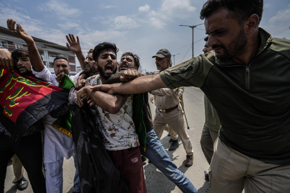 Indian policemen detain Kashmiri Shiite Muslims for participating in a religious procession during restrictions in Srinagar, Indian controlled Kashmir, Sunday, Aug. 7, 2022. Authorities had imposed restrictions in parts of Srinagar, the region's main city, to prevent gatherings marking Muharram from developing into anti-India protests. (AP Photo/Mukhtar Khan)