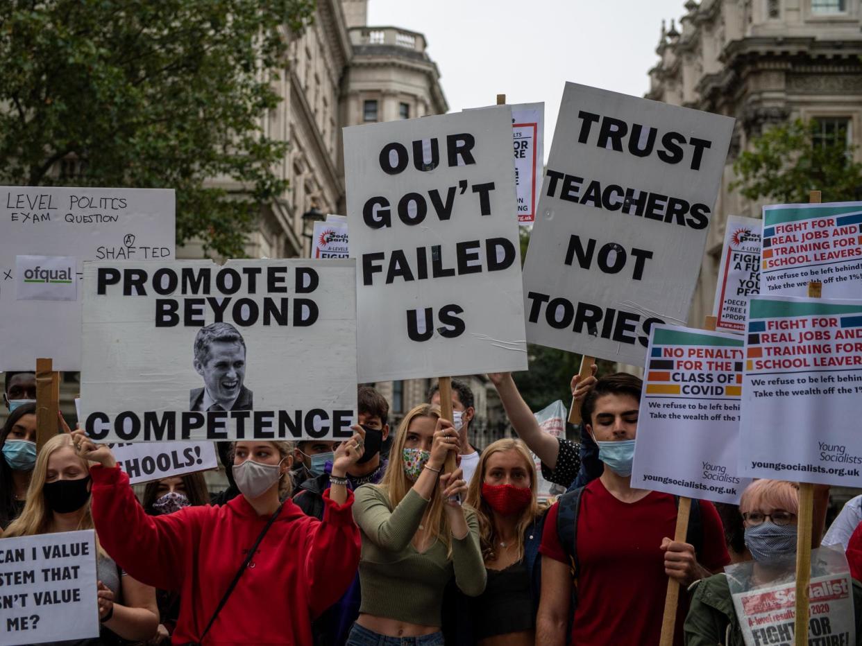 Students, teachers and parents hold placards and wear face masks as they protest against downgraded results: Chris J Ratcliffe/Getty Images