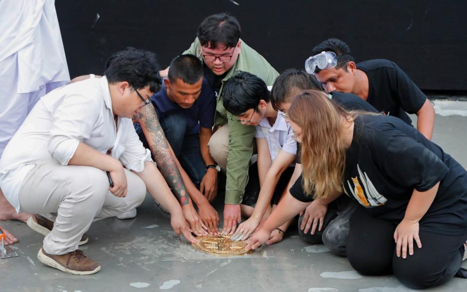 Pro-democracy student leaders install a plaque declaring "This country belongs to the people" at the Sanam Luang field - AP