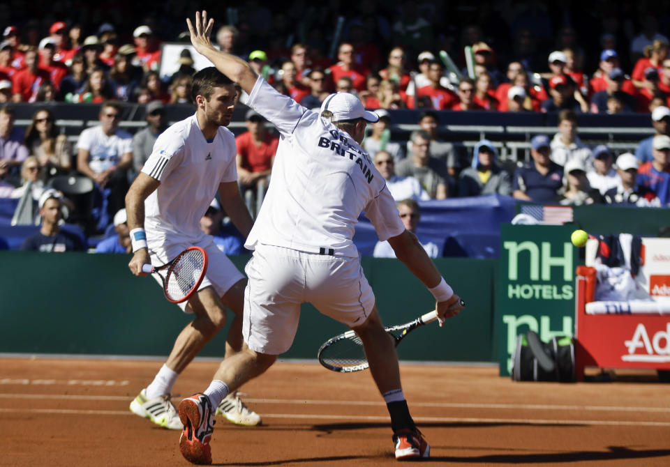 Britain's Dominic Inglot returns a shot from the United State team as his teammate Colin Fleming looks on during a doubles match at the Davis Cup tennis matches, Saturday Feb. 1, 2014, in San Diego. (AP Photo/Lenny Ignelzi)