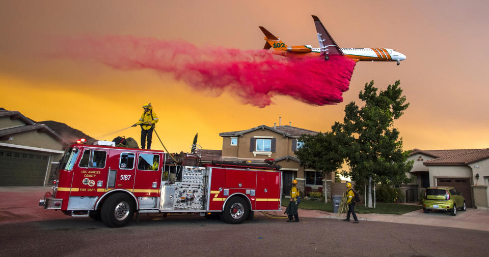 <p>A plane drops fire retardant behind homes along McVicker Canyon Park Road in Lake Elsinore, Calif., as the Holy Fire burned near homes on Wednesday, Aug. 8, 2018. (Photo: Mark Rightmire/The Orange County Register via AP) </p>