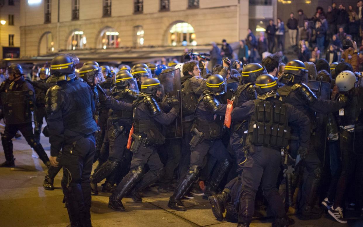 Anti riot police officers push a group of demonstrators during scufflings in Paris - AP