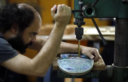 Argentine luthier Ezequiel Galasso drills into a skateboard at his workshop in Buenos Aires October 17, 2014. REUTERS/Marcos Brindicci