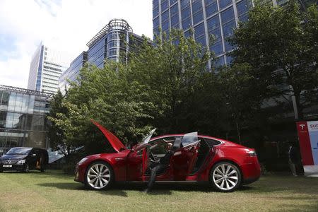 A visitor looks at a Tesla Model S electric car at the Motorexpo in Canary Wharf, London, June 13, 2014. REUTERS/Marika Kochiashvili