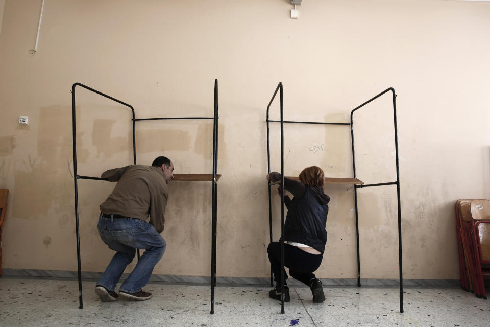 Municipal workers assemble voting booths at a voting center in Athens, Friday, Jan. 23, 2015. (AP Photo/Petros Giannakouris)