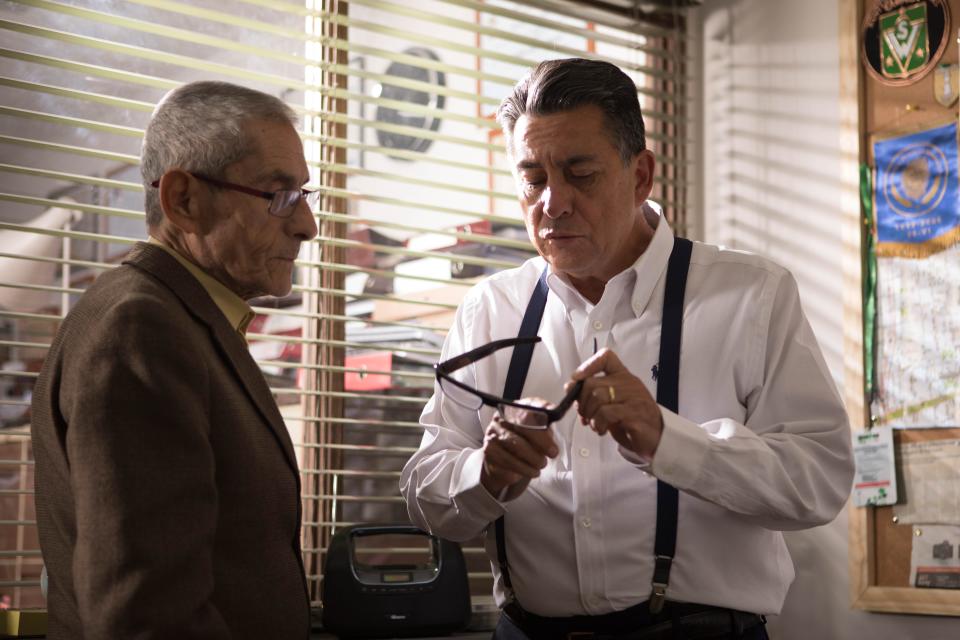 Sergio Chamy (left) gets outfitted with glasses that have a secret camera by private investigator Romulo Aitken in the documentary "The Mole Agent."