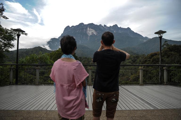 Tourists take photos of Malaysia's Mount Kinabalu, a day after an earthquake struck the area, in Kundasang, a town in the district of Ranau, on June 6, 2015