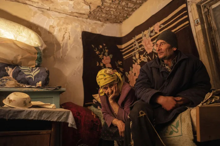 Nina Gonchar, 93, and her son Mykola Gonchar, 58, sit inside their house which was mostly destroyed by Russian forces in the recently retaken village of Bogorodychne, Ukraine, Saturday, Jan. 7, 2022. Gonchar's son Vasyliy and his wife Liubov were killed by Russian shelling on July 10, 2022. (AP Photo/Evgeniy Maloletka)