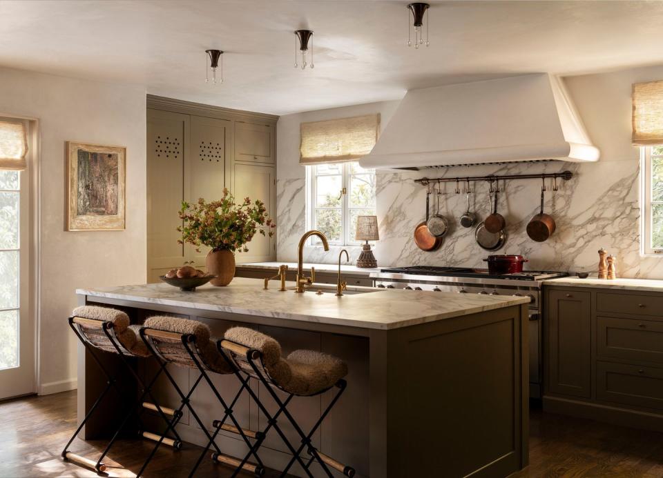 a kitchen with a stove and chairs