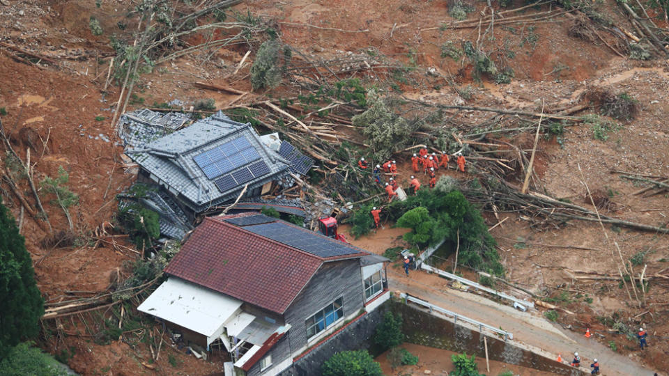 People can be seen trying to work through the flooding wreckage.