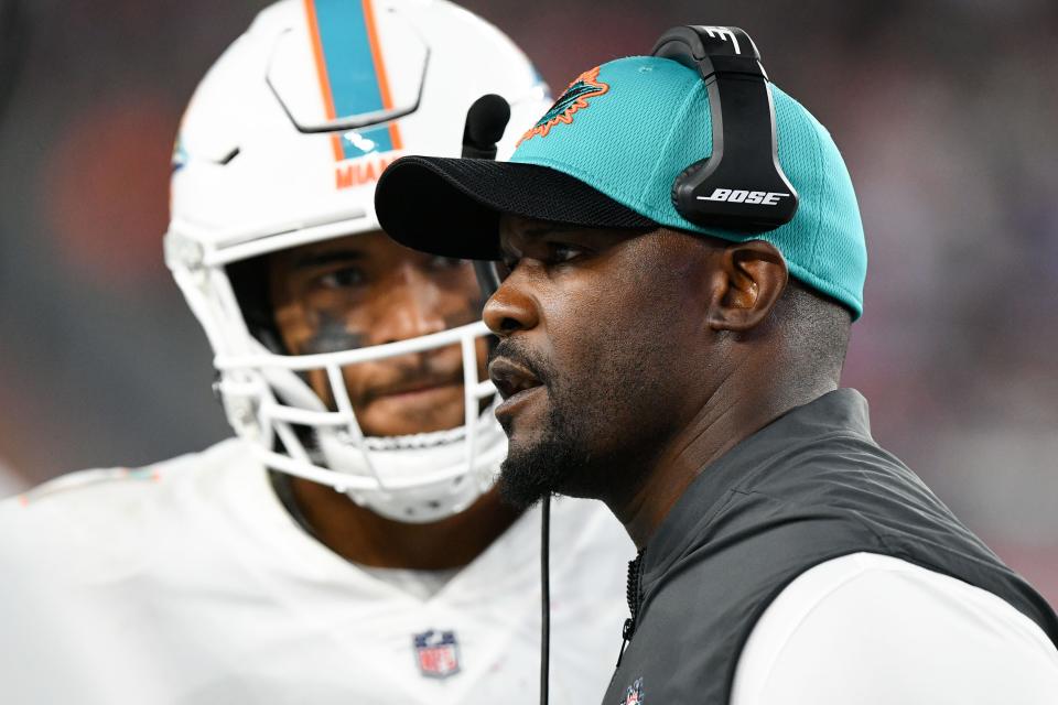 Brian Flores talks with Tua Tagovailoa during a 2021 game at New England.