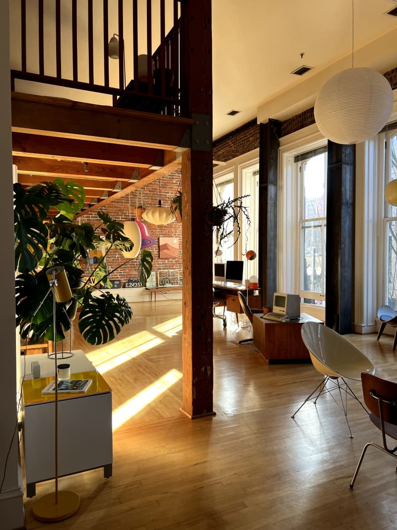 Floor-to-ceiling windows seen in loft with wood flooring.