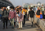 NEW DELHI, INDIA - MARCH 28: Migrant workers along with their family members walk to their villages amid the nationwide lockdown, in wake of coronavirus (COVÄ°D-19) pandemic, at Delhi Uttar Pradesh Border, in New Delhi on March 28, 2020. (Photo by Amarjeet Kumar Singh/Anadolu Agency via Getty Images)