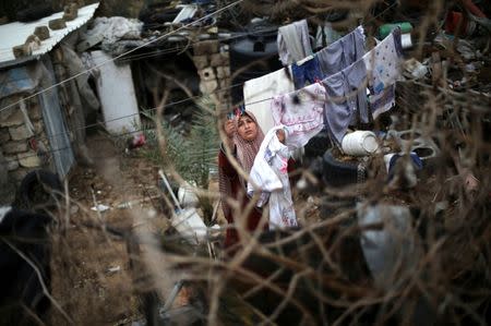 A Palestinian woman hangs laundry on a rope to dry outside her dwelling in Khan Younis in the southern Gaza Strip. REUTERS/Ibraheem Abu Mustafa