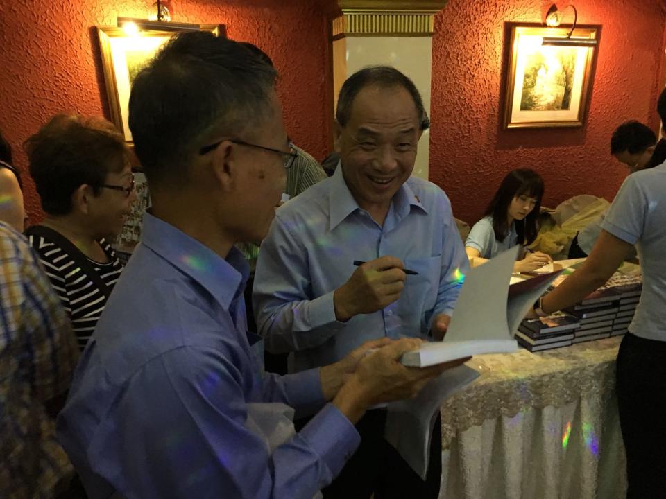 Workers’ Party secretary-general Low Thia Khiang signs a copy of a commemorative book on the party on 3 November. (PHOTO: Nicholas Yong / Yahoo News Singapore)