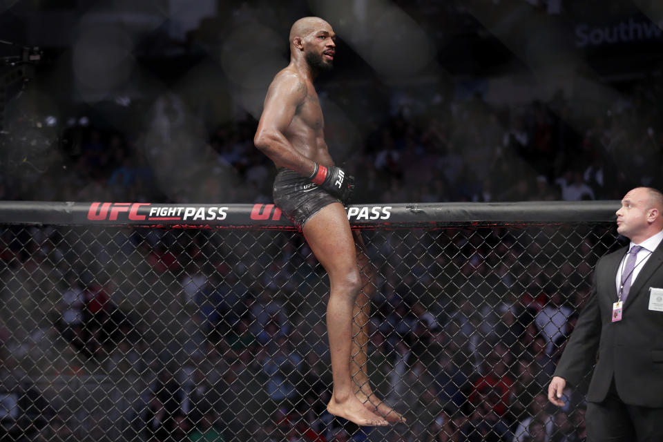 Jon Jones climbs onto the fence immediately after a light heavyweight mixed martial arts bout against Dominick Reyes at UFC 247 Sunday, Feb. 9, 2020, in Houston. (AP Photo/Michael Wyke)