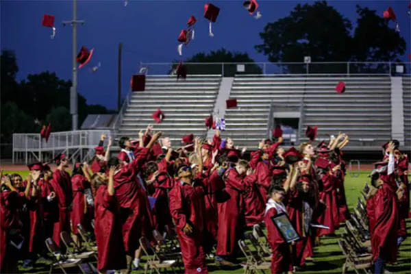 Graduates throw their caps into the air in celebration at the graduation ceremony (Kylie Cooper/The Texas Tribune)