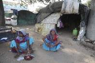 Indian residents of a slum near Sardar Patel Gujarat Stadium sit in front of their hut in Ahmedabad, India, Tuesday, Feb. 18, 2020. Authorities on Monday served eviction notices to 45 families living in the slum area ahead of the visit of U.S. President Donald Trump. Trump is visiting the city of Ahmedabad in Gujarat during a two-day trip to India next week to attend an event called “Namaste Trump,” which translates to “Greetings, Trump,” at a cricket stadium along the lines of a “Howdy Modi” rally he hosted for Indian Prime Minister Narendra Modi in Houston last September.(AP Photo/Ajit Solanki)