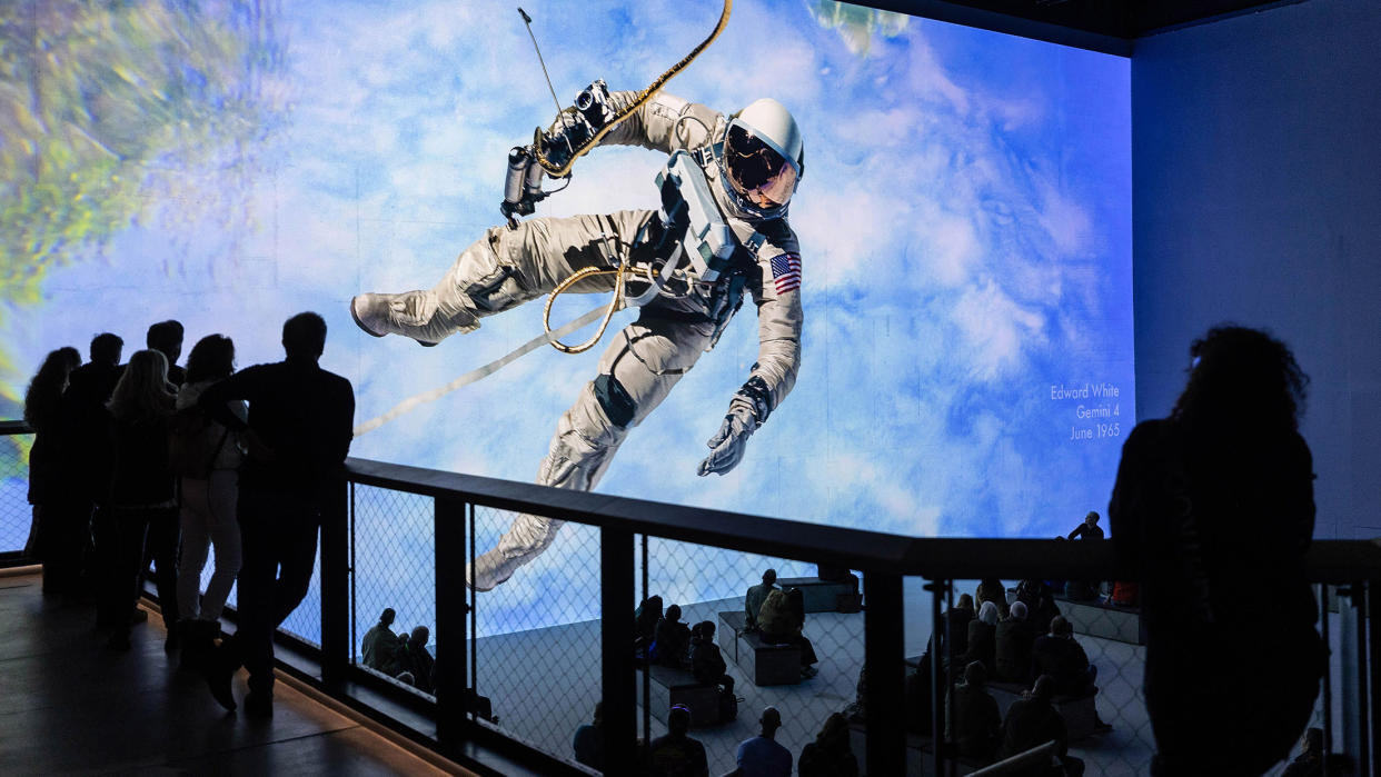  An astronaut hovers over a space station in an immersive projection-mapping spectacle. . 
