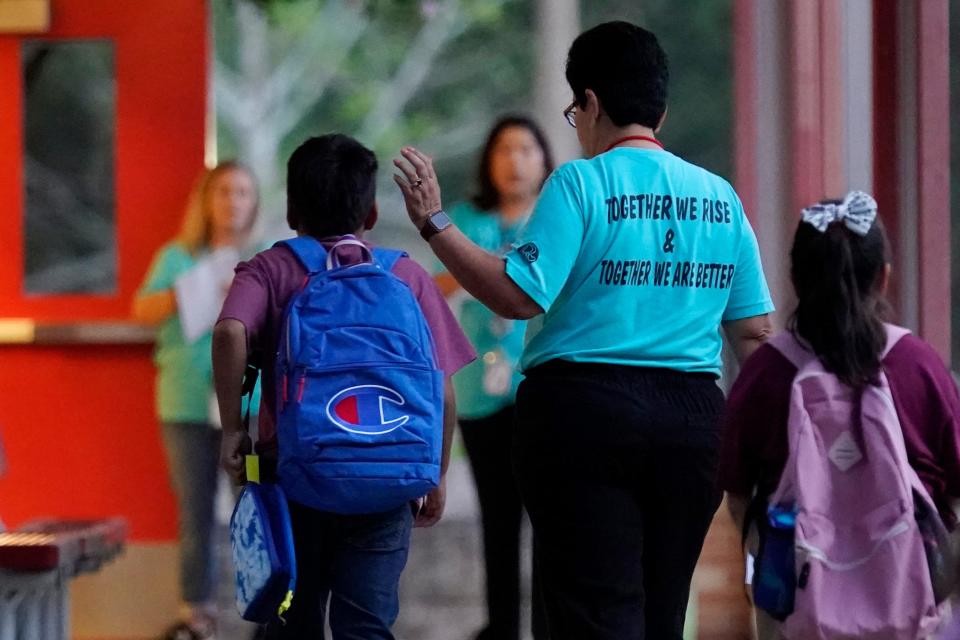 Students arrive at Uvalde Elementary, now protected by a fence and Texas state troopers, for the first day of school, Tuesday, Sept. 6, 2022, in Uvalde. Students in Uvalde returned to campuses for the first time since the shootings at Robb Elementary in which two teachers and 19 students were killed.