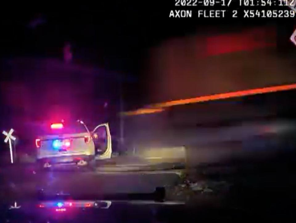 The moment before a train impacts a Platteville, Colorado police cruiser. Yareni Rios-Gonzalez, 20, who was being detained while police searched her truck after a stop involving a road rage incident, was inside the cruiser when the train hit (Screengrab/Fort Lupton)