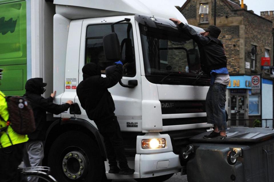 Protesters clinging to a lorry which drove through the barricade. (PA)