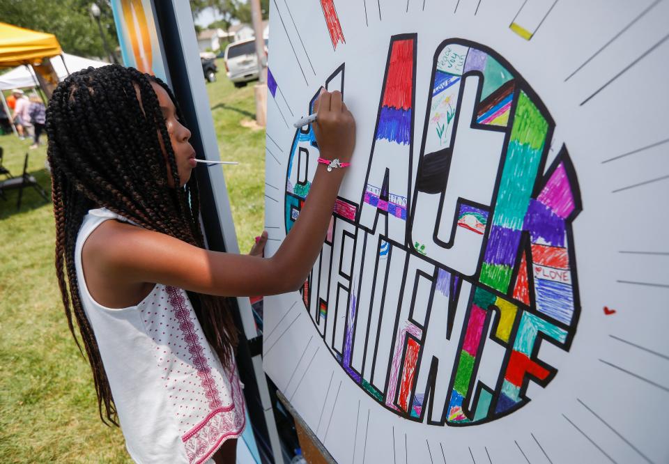 Ariana Morris, 10, colors a sign that reads, "Black Excellence" during the Juneteenth celebration at Silver Springs Park on Saturday, June 19, 2021.